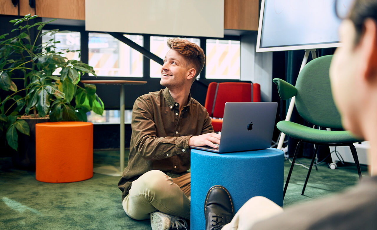 Jongen zit met laptop op de grond