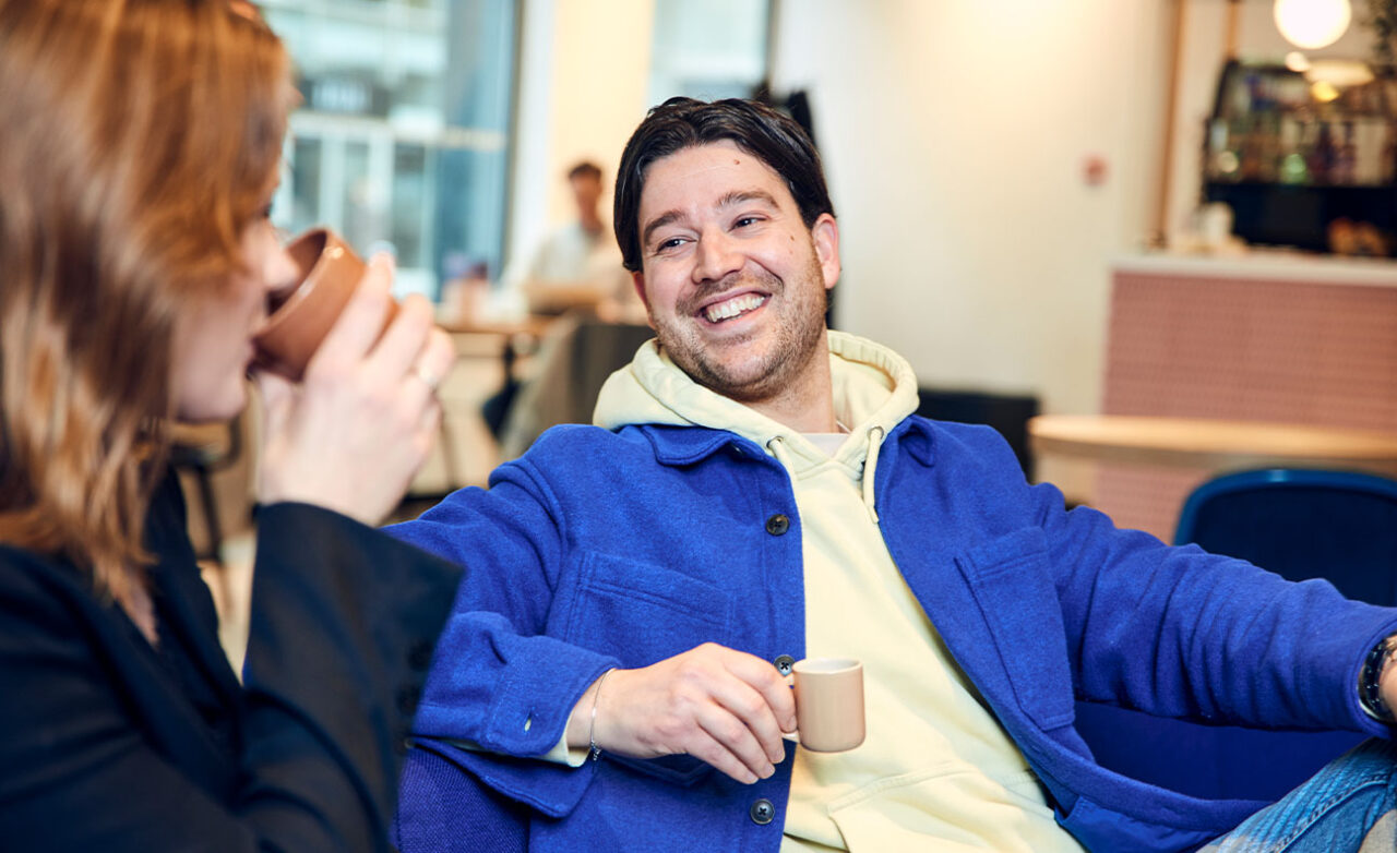 Man is in gesprek met koffie in zijn hand