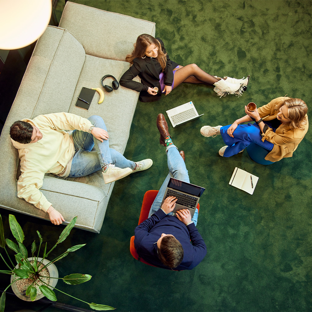 4 collega's zitten informeel op de grond te werken