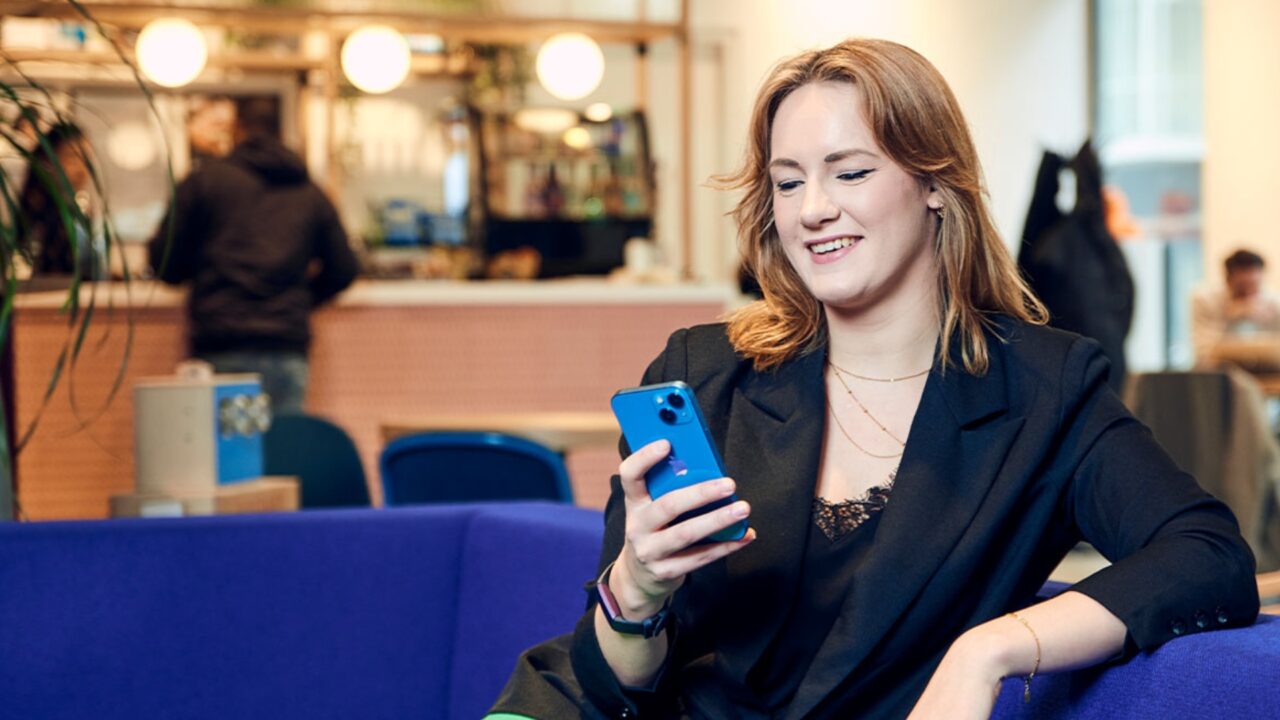 Vrouw op telefoon blauwe bank