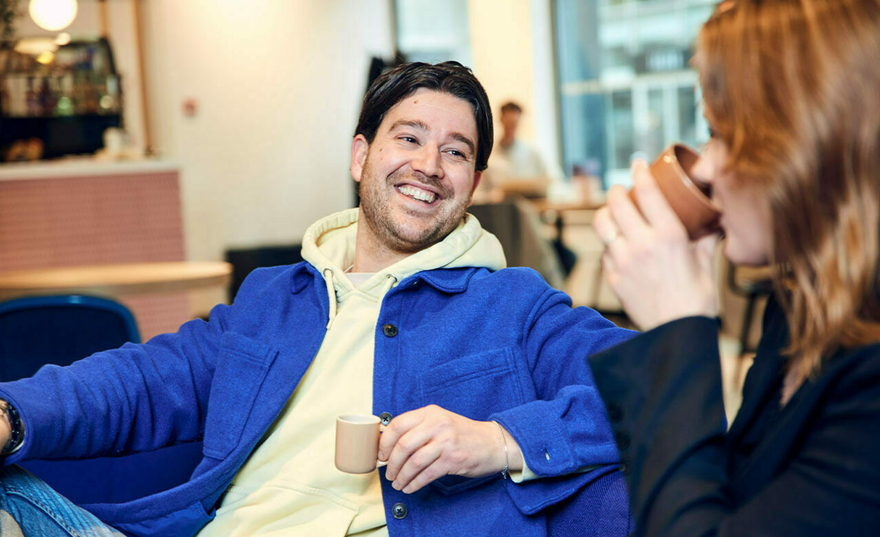 Man met koffie in gesprek